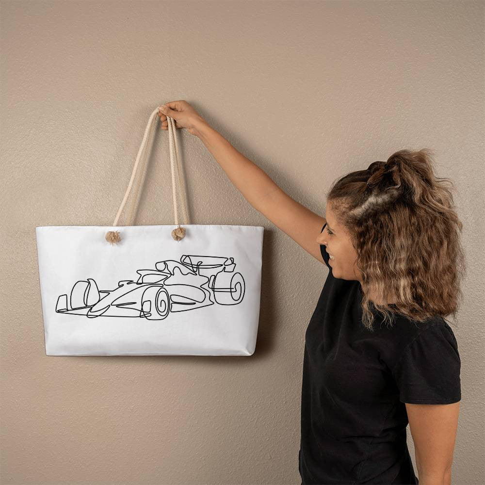 Person holding a white F1 merch fan inspired tote bag