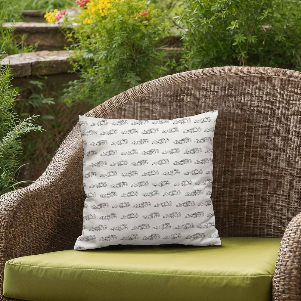 White Formula 1 pillow with black cars sitting on patio chair